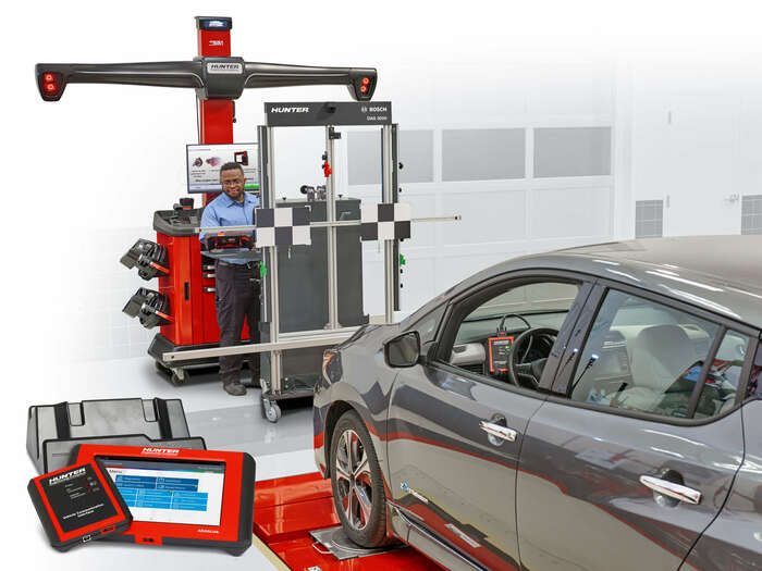 Technician adjusting DAS 3000 equipment in service bay with ADASLink products presented in foreground.