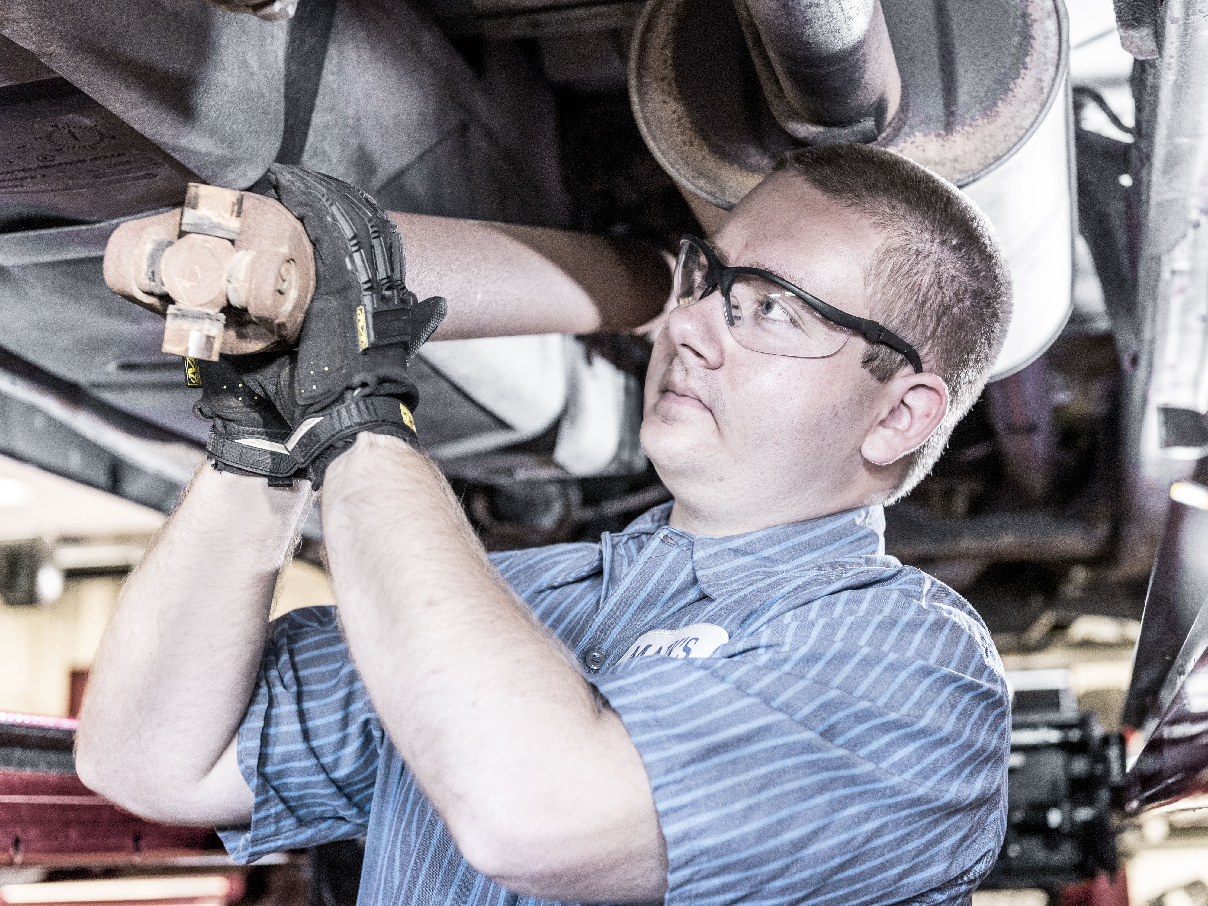 technician removing drive train components from vehicle