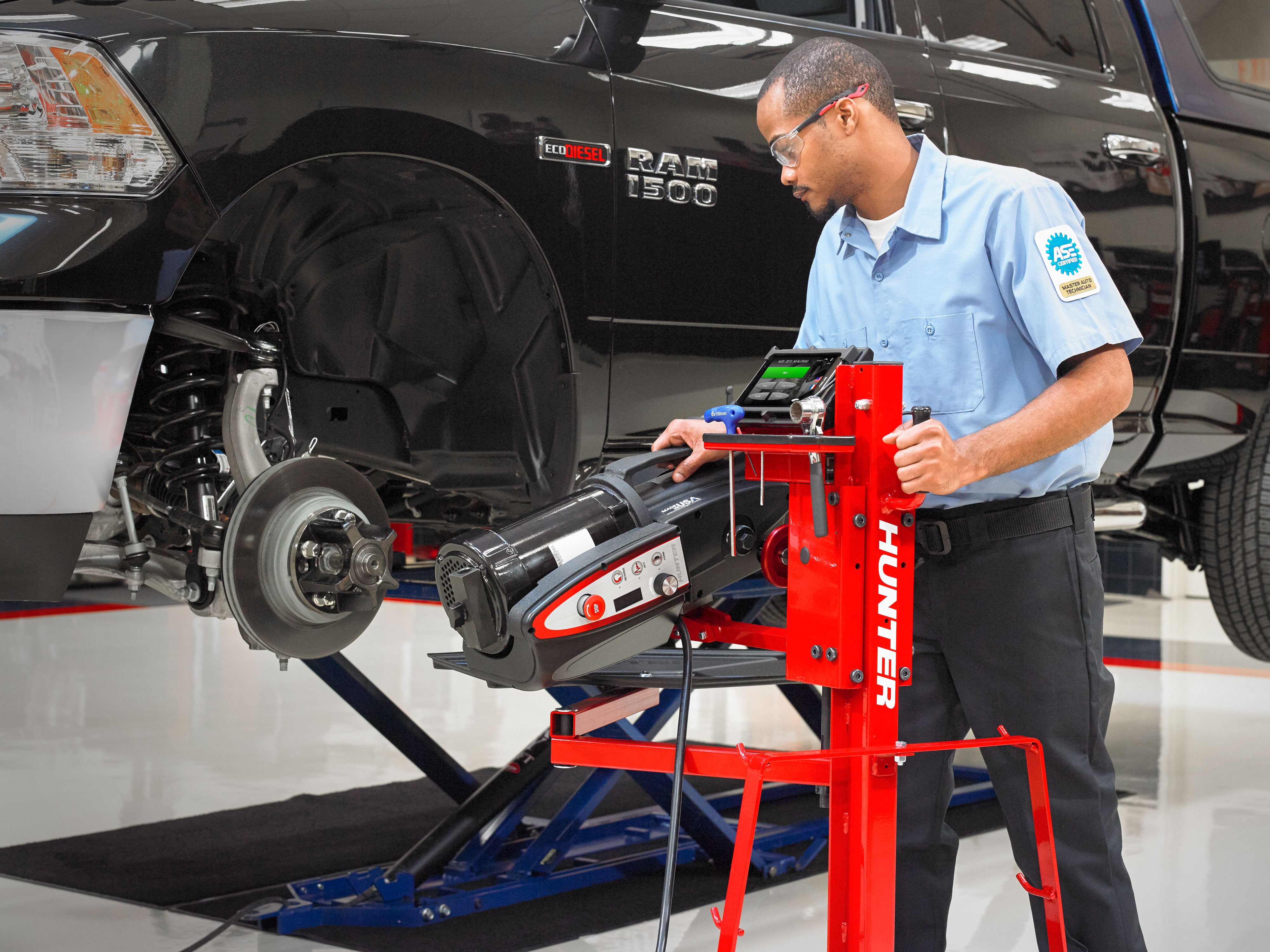 técnico utilizando el torno para frenos AutoComp Elite de Hunter en el rotor del vehículo