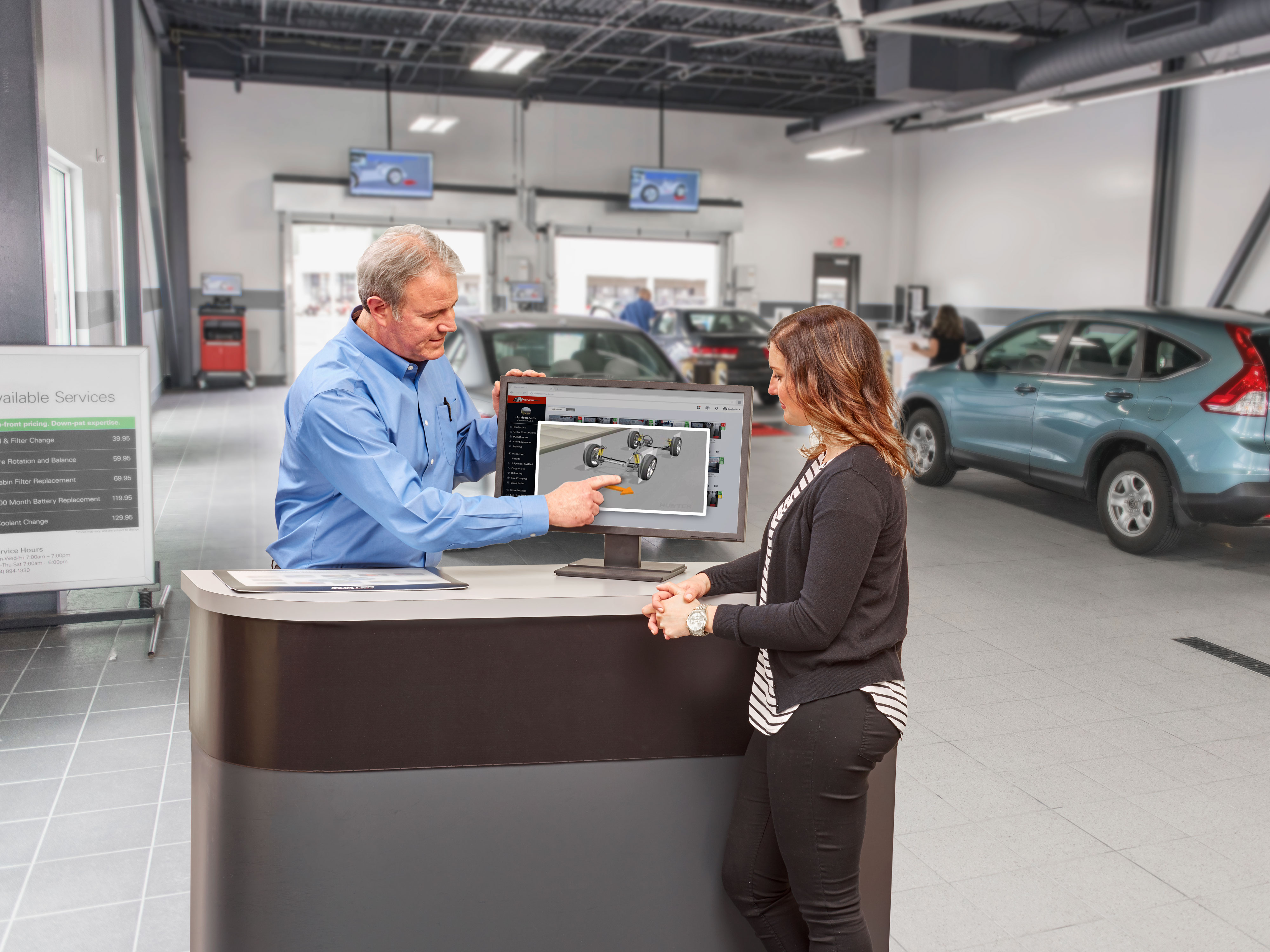 service advisor explaining wheel alignment video to customer