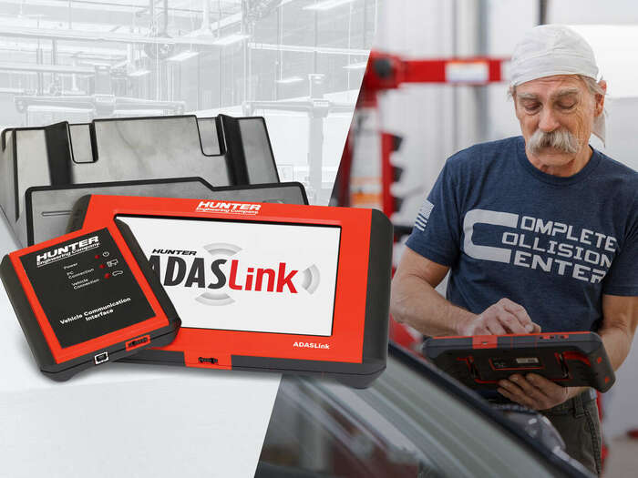 Close-up view of the ADASLink diagnostic scan tool, with a technician actively using it in an automotive shop setting.